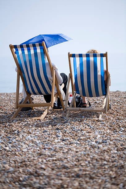 Two deckchairs on the Brighton beach stock photo
