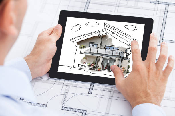 istock Businessman Holding Blank Digital Tablet Over Blueprint 917202962