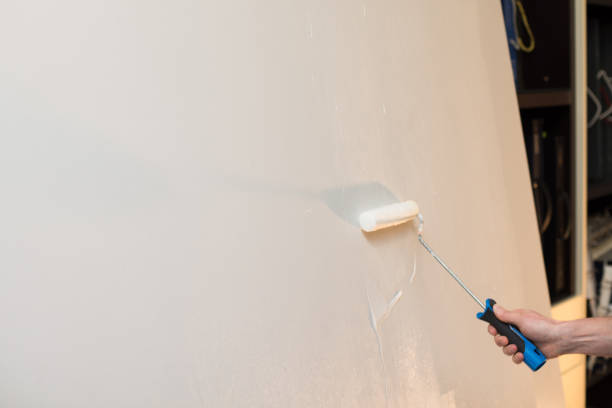 istock Close up of hand painting wall with roller. Copy space. 917203852