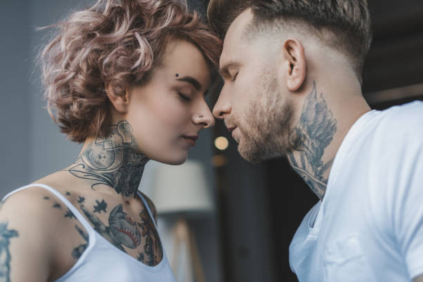 istock young tender tattooed couple touching noses with closed eyes 917206172