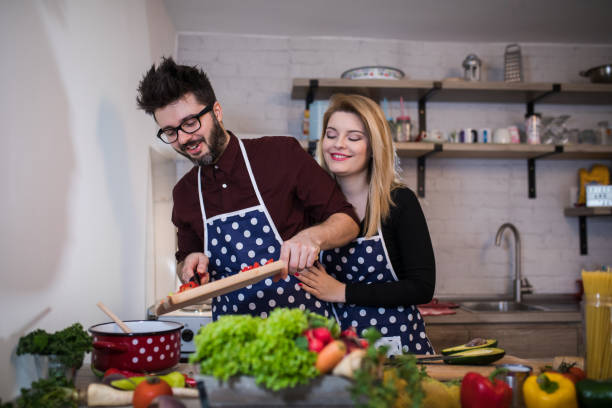 istock Smiling young couple cooking food in the kitchen 917206362