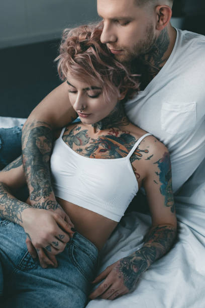 istock tattooed tender couple relaxing together on bed 917209748