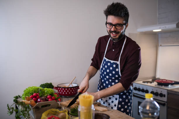 istock Handsome man cooking vegetable salad in kitchen 917210548