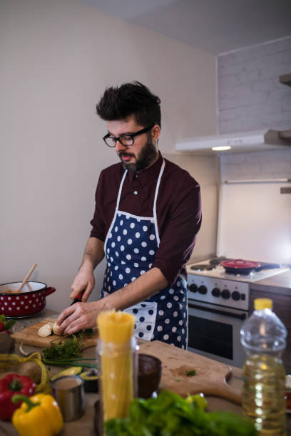 istock Handsome man cooking vegetable salad in kitchen 917210858