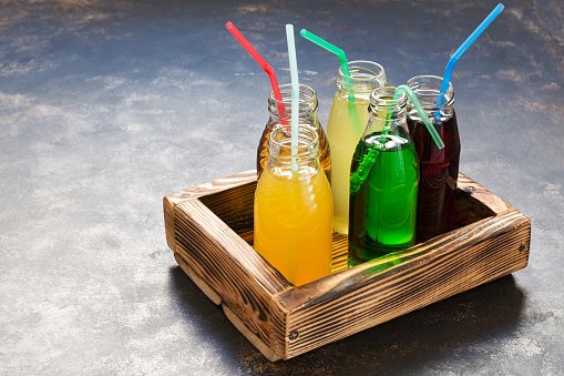 Glass bottles with different juices in a wooden box. The concept of healthy eating