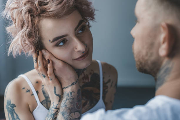istock tender tattooed man touching face of his attractive girlfriend 917211458