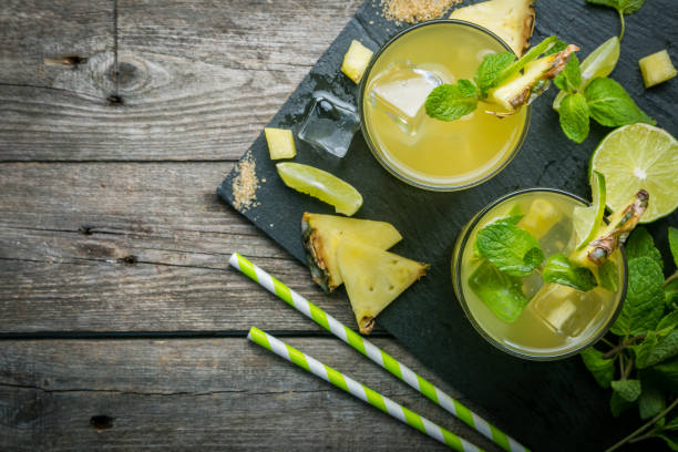 Pineapple and lime drink on rustic background stock photo
