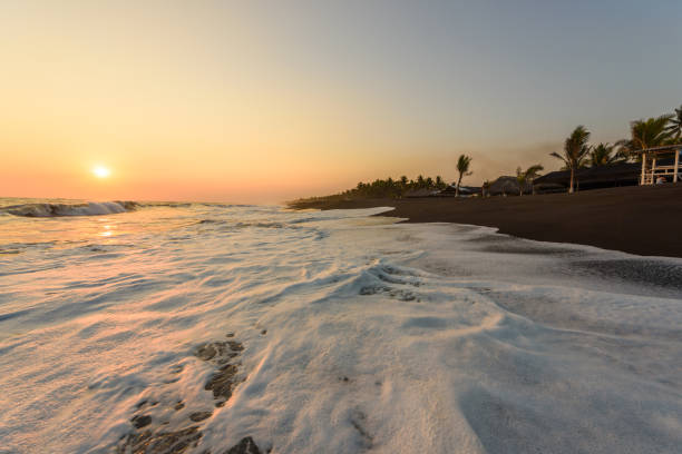 pôr do sol na praia de areia preta em monterrico, guatemala. conhecida por suas praias de areia negras vulcânicas e afluxo anual de tartarugas marinhas. destino de viagem da guatemala. monterrico situa-se na costa do pacífico, no departamento de santa rosa. - pacific ocean - fotografias e filmes do acervo