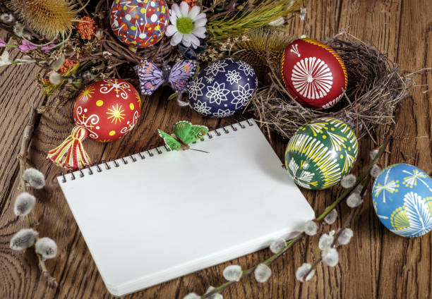 istock Easter theme. Easter greeting card colored Easter eggs and blooming willow over wooden background with copy space. 917229442