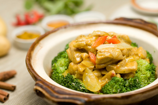 Stir-fried Broccoli and fried soft tofu, healthy Asian homemade menu, food in white plate that place on wooden cutting board in a kitchen, close up the food, natural lighting image.