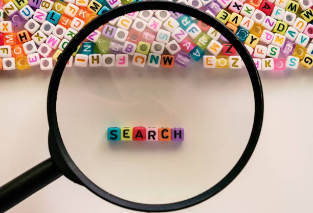 検索単語、アルファベット文字ビーズ検索エンジン最適化の概念のための白い背景の上に虫眼鏡で拡大、カラー フィルターを追加 - magnifying glass book scrutiny research ストックフォトと画像