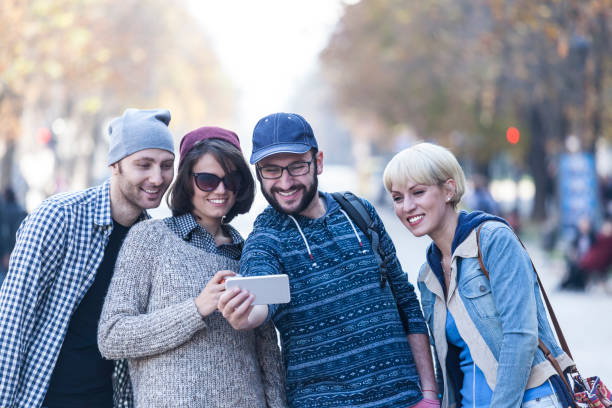istock Young people walking on street and taking selfie 917235902