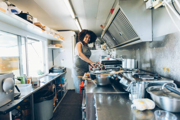 istock Smiling female food van worker making sandiches 917236044