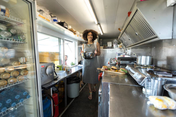 istock Smiling female food van worker making sandiches 917236048