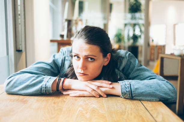 istock Pensive young woman sitting in cafe alone 917236094