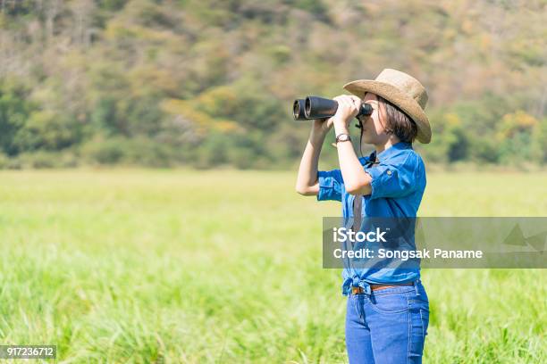 Young Teenager Wear Hat And Hold Binocular In Grass Field Stock Photo - Download Image Now