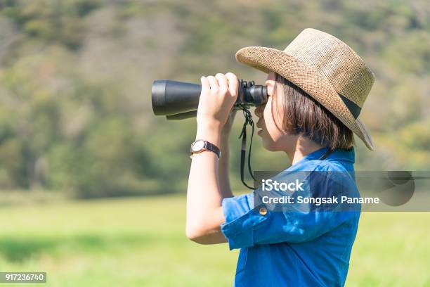 Young Teenager Wear Hat And Hold Binocular In Grass Field Stock Photo - Download Image Now