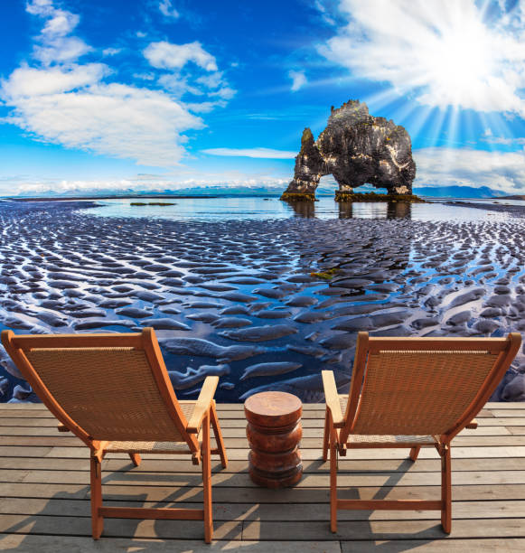 Magic Rock Hvitsercur on northern coast of Iceland. Two wooden deck chairs are on the beach. Concept of extreme northern tourism