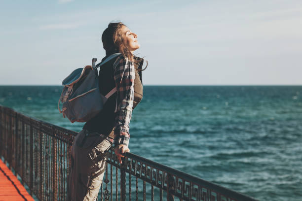 Take a moment to appreciate the peace and beauty around Young woman with eyes closed enjoying the air and sea on a sunny day carefree stock pictures, royalty-free photos & images