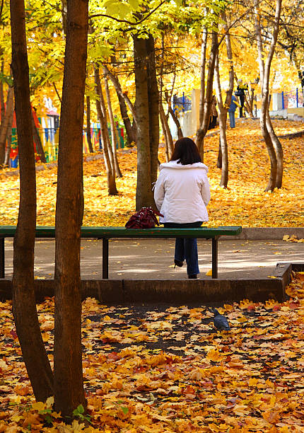 istock girl on bench in autumn park 91724467
