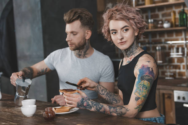 istock young tattooed couple eating toasts and drinking coffee for breakfast 917245372