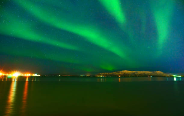 northern light from the beachside in reykjavik, iceland. - clear sky flash imagens e fotografias de stock