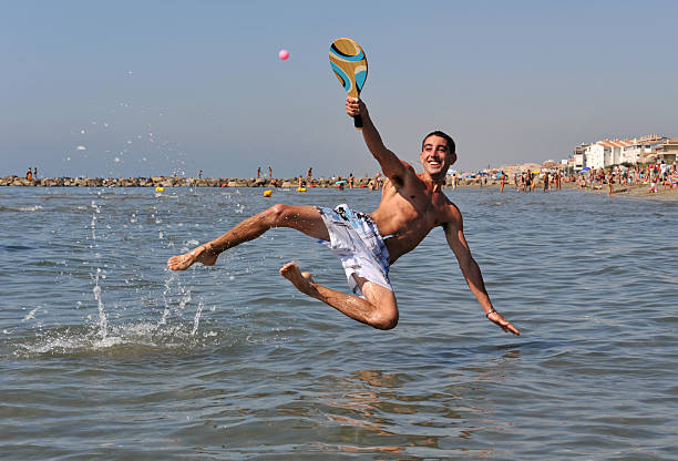 Teenager enjoying the first day on the Sardinia beach. He is enjoying the crystal clear water, running and splashing in the sea.\nShot with Canon R5.