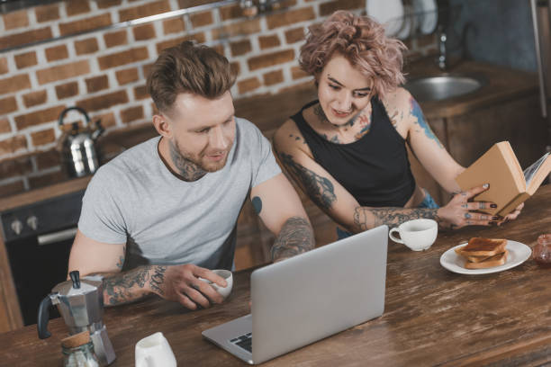 istock young couple using laptop and reading book during breakfast in kitchen 917251048