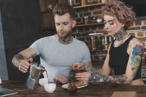 istock tattooed couple eating toasts and drinking coffee for breakfast 917251418