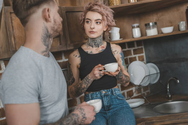 istock young tattooed couple drinking coffee together at morning 917252708