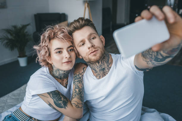 istock handsome tattooed man taking selfie with girlfriend in bedroom 917252790
