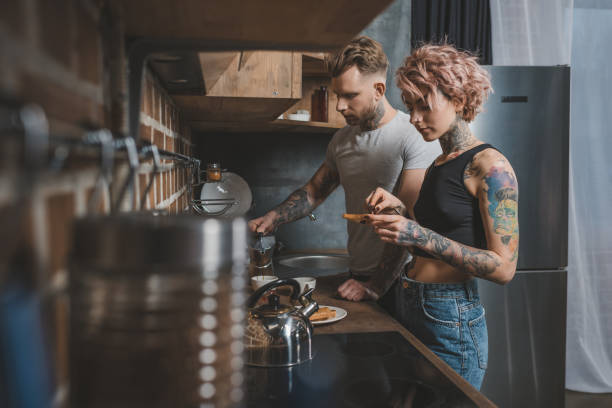 tattooed couple making breakfast at kitchen