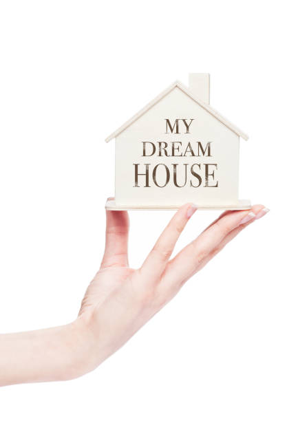 istock Female hand holding wooden house model with text 917256276