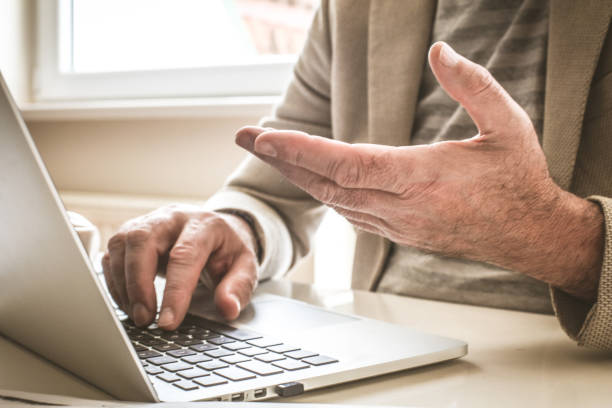 istock Mature businessman hands working on laptop. Close up. 917256674