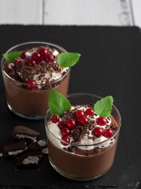 istock Chocolate mousse with currant and mint in a glasses on a black stone background. 917263190