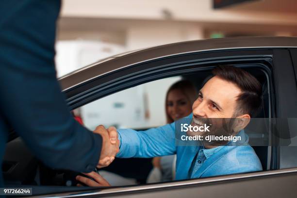 Photo libre de droit de Jeune Couple Se Serrant La Main Après Lachat Dune Voiture Réussie banque d'images et plus d'images libres de droit de Voiture