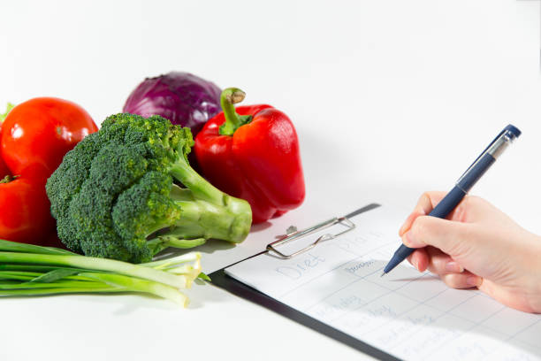 istock Female nutritionist doctor hand writing diet plan 917270174