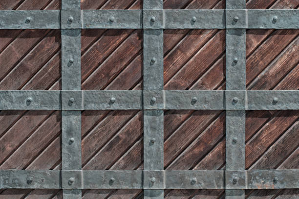 Wooden gate of the castle behind a grating