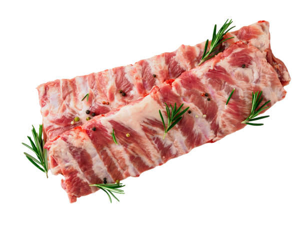 immagine isolata di costolette di maiale crude con rosmarino stagionato, pepe su sfondo bianco, vista dall'alto - sparerib foto e immagini stock