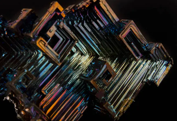 Rainbow colorful mineral bismuth closeup macro on a dark background