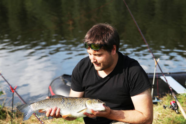 istock Young man with tent while fishing 917273514