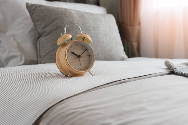 istock wooden modern alarm clock on bed 917273586