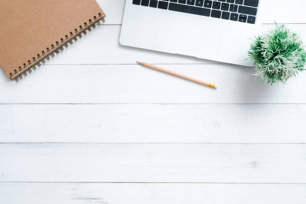 istock Minimal work space - Creative flat lay photo of workspace desk. Top view office desk with laptop, mock up notebooks and plant on white wooden background. Top view with copy space, flat lay photography 917273896