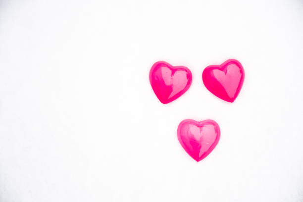 Theree small purple pink hearts with shadow on snow white background, idea for card on valentine's day or woman's day, love is wonderful, romantic and sweet meoment.