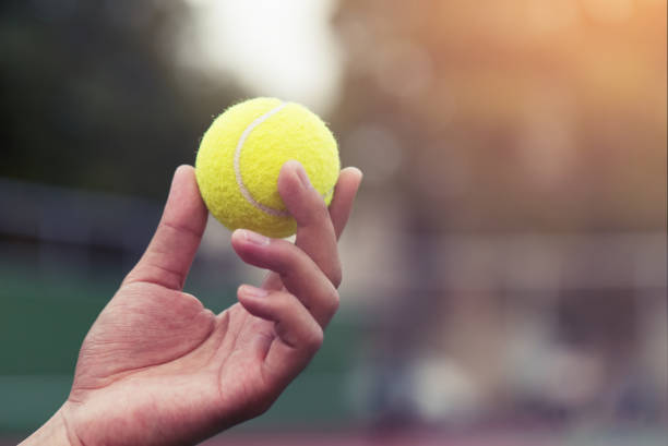 tennis-spieler hält den ball und immer bereit zu dienen. - tennisball stock-fotos und bilder