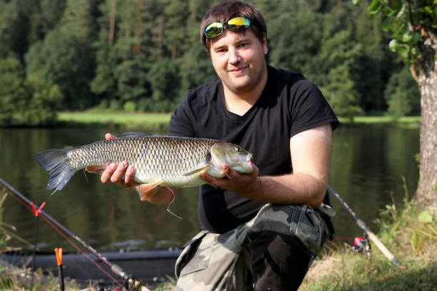 istock Young man with tent while fishing 917279776