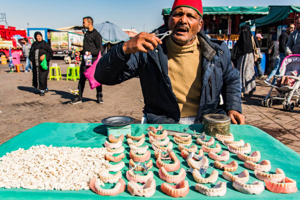 homem fazendo prótese como vendedor de rua em marrocos - djemma el fna square - fotografias e filmes do acervo