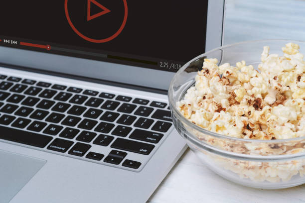 istock Popcorn in bowl and laptop playing movie 917287486