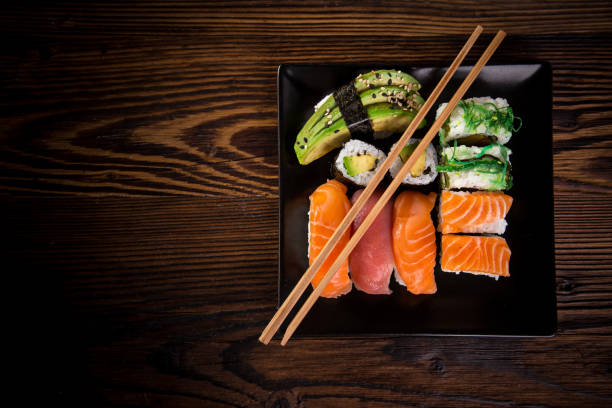 Various kinds of sushi served on wooden table