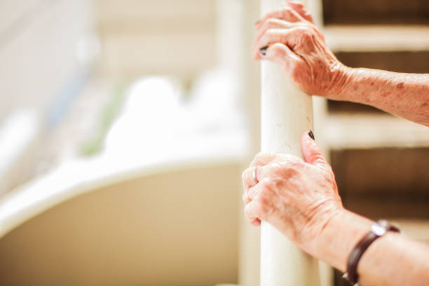 istock Elderly woman's hands climbing stair using handrail with copy space, white background 917291178